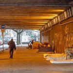 Homeless Camps HID Massive Fentanyl Distribution Ring People walk under a bridge with homeless encampment.