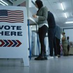 Former Mayor’s Illegal Vote Sparks National CHAOS Sign reading Vote Here in a polling station.