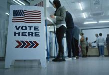 Former Mayor’s Illegal Vote Sparks National CHAOS Sign reading Vote Here in a polling station.