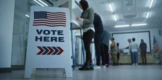 Former Mayor’s Illegal Vote Sparks National CHAOS Sign reading Vote Here in a polling station.