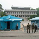 Ceasefire COLLAPSE Looms: Trump’s Dire Prediction Military personnel standing near blue buildings at a border crossing