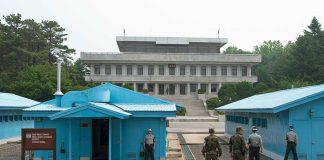 Ceasefire COLLAPSE Looms: Trump’s Dire Prediction Military personnel standing near blue buildings at a border crossing