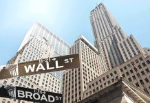 Street signs for Wall Street and Broad Street with skyscrapers in the background