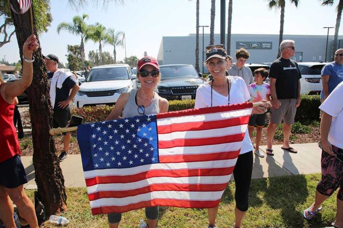 Two women holding an American flag at a community event