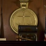 Judge Blocks $10B Trump Suit—Epic Clash Over Epstein A judges bench in a courtroom with a gavel and flags