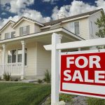Housing Crisis EXPOSED: Massive Price Divide! A suburban house with a For Sale sign in the front yard