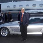 Wealth Shift: RICH GO BOLD in 2026! A man in a suit poses next to a silver luxury car in front of a private jet