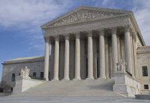 The Supreme Court building featuring large columns and statues