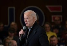 Viral Clip Warps Biden Moment Man speaking into a microphone at an event.