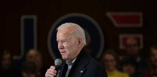 Viral Clip Warps Biden Moment Man speaking into a microphone at an event.