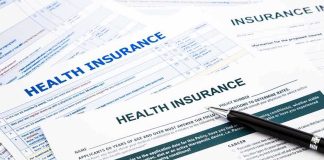 Close-up of health insurance application forms with a pen