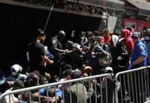 A group of people interacting with police officers in an urban environment