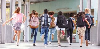 Grooming Scandal Bombshell: Files Reopened Children running with backpacks outside a school building.