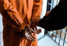 Morality Police Put Pain On Display Handcuffed person in orange jumpsuit being escorted.