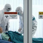 Hidden Spray Sickens Dozens—Source Unknown Healthcare workers in protective gear in quarantine room.