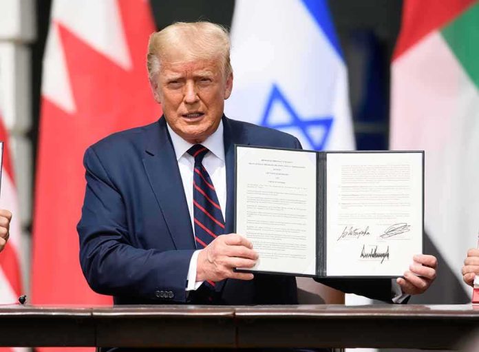 Man in navy suit holding an open signed document at a ceremony