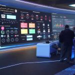 cybersecurity operations room with large data dashboards and people discussing