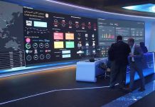 cybersecurity operations room with large data dashboards and people discussing