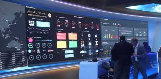 cybersecurity operations room with large data dashboards and people discussing