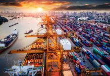Container port with cranes and cargo ships at sunset