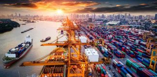 Container port with cranes and cargo ships at sunset