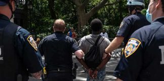 Armed Stalker Nabbed At Trump Golf Club Police escort a handcuffed man across a city street