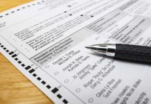 Ballot paper with pen on wooden surface