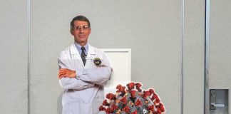 Shocking Pick to Succeed Fauci Cardboard cutout of doctor with COVID-19 virus info display