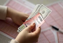 Hands holding lottery tickets and U.S. dollar bills