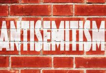 Brick wall with large white stencil text