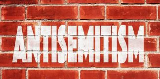 NYC Missed the Warning Signs Before Jewish Mother Was Killed Brick wall with large white stencil text