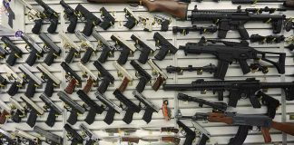 Wall display with handguns and rifles for sale.