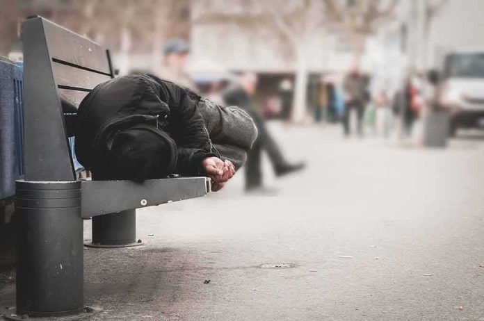 Person lying on a bench in an urban street