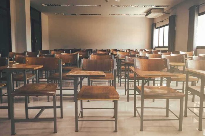 shutterstock_1019829787 Empty classroom with rows of wooden desks and chairs
