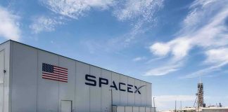 SpaceX hangar beside launch pad under blue sky