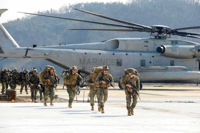 shutterstock_1123252001 Soldiers disembark and walk past a large military helicopter