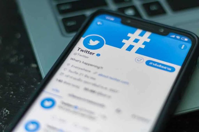 Smartphone displaying Twitter app on a laptop keyboard
