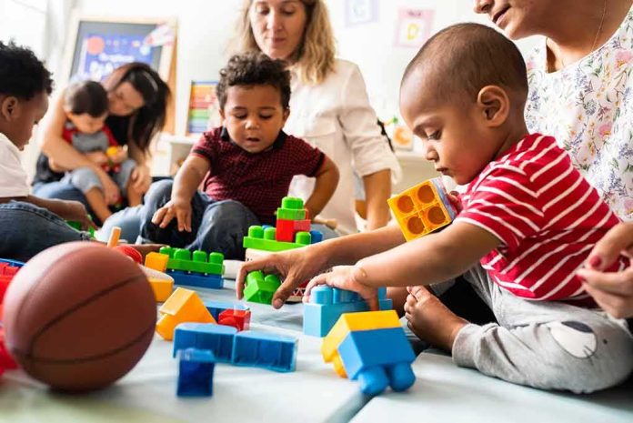 shutterstock_1247691913-1 Karyn Polito with toddlers building blocks on a play mat