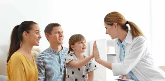 Doctor high-fives a smiling child during family visit