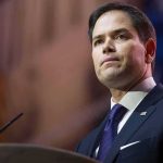 Fired DeSantis Aide Lands TOP Job With Rubio man in suit speaking at podium