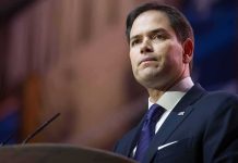 Fired DeSantis Aide Lands TOP Job With Rubio man in suit speaking at podium
