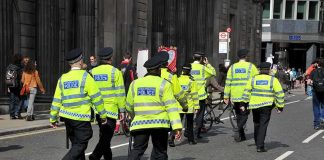 Police officers in high-visibility jackets walking on a city street
