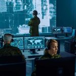 Space Jammers Target U.S. Precision Military analysts monitor data on multiple screens in a command center