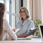 Royce White Declares Himself Trans as WNBA Journey Begins Smiling woman with gray hair talking in a modern office