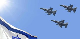 Israeli flag with three fighter jets flying overhead