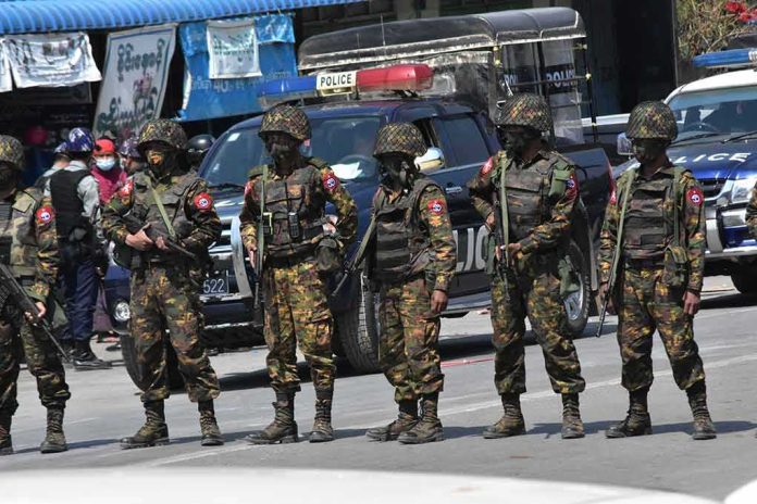 Group of soldiers in camouflage uniforms standing in a street; Brenton Bersin and Shaquille Riddick present