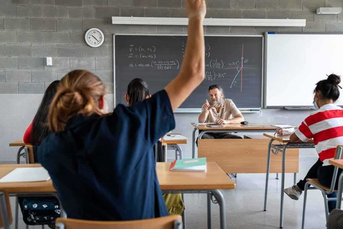 Student raising hand in classroom during lesson
