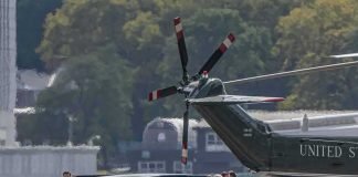 Motorcade and helicopter on a waterfront helipad