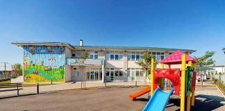 Playground with colorful slide in front of a school building