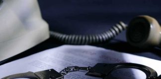 Smart Ring CEO Convicted in $2 Million Scheme Handcuffs on a document beside a coiled telephone handset